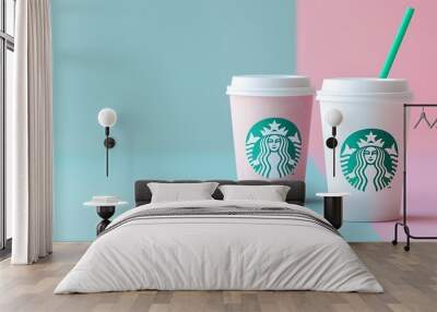 Two Starbucks coffee cups with green straw isolated on pink and blue background Wall mural