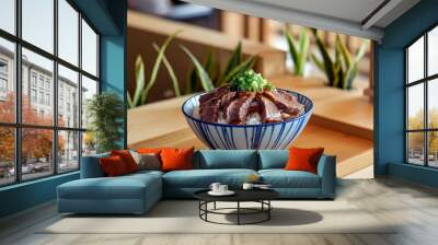 A delectable bowl of Gyudon, featuring tender Japanese beef over rice, served in a cozy restaurant setting, capturing the essence of authentic Japanese cuisine.  Wall mural