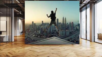 Young man jumping on rooftop with great cityscape sunrise view. Wall mural