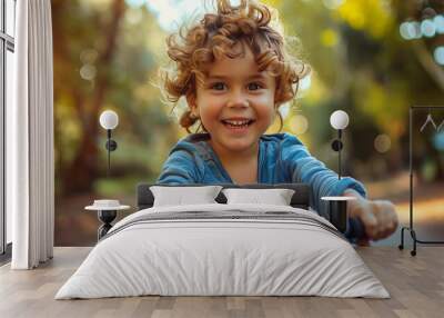 Cute little boy riding his bike, happy after learning to ride it earlier this week. Wall mural