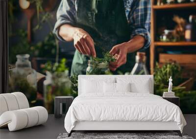 Person preparing fresh herbs in a cozy kitchen setting. Wall mural