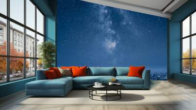 A city at night with an epic milky way on the sky Wall mural