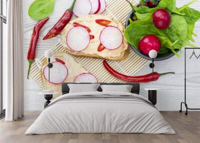 Bread with a spicy cheese spread, pieces of peppers, slices of radish and baby spinach. Healthy and spicy breakfast concept. Wall mural