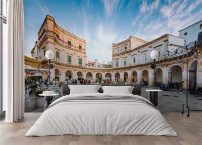 Largo Piazza Maria Immacolata in the historic center of Martina Franca at sunset with people walking around Wall mural