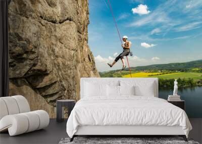 Girl abseiling above Vltava river on beautiful sunny day, Czech republic Wall mural