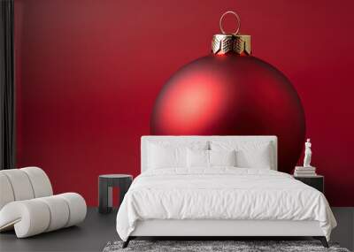 Red Christmas bauble on vibrant red background, festive decoration. Wall mural