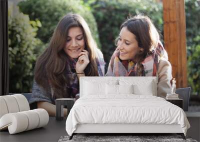 Two young friends shopping online with a credit card and a phone Wall mural