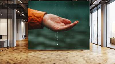 hand catching a water droplet orange coat rain background Wall mural