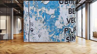 Grunge texture of blue metal pole with old torn paper and torn black lettering Wall mural