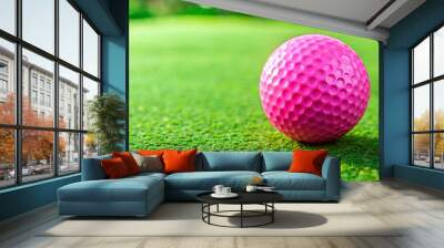 Single pink golf ball on green putting green representing precision focus and goal pursuit Wall mural