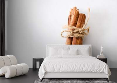 Cinnamon sticks dried tree bark spice on white table background. Selective focus. Wall mural