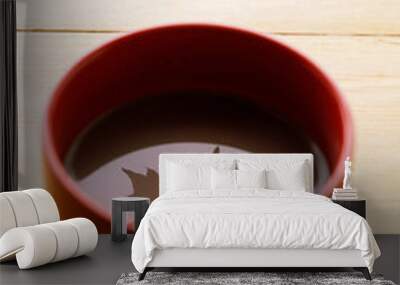 Cup of delicious hot chocolate with red maple leaf reflection on wooden table background. Selective focus. Wall mural