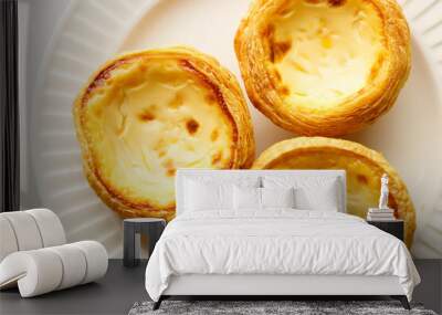 Stack of Portuguese sweet dessert egg tart or Pastel de Nata on white ceramic plate on white table. Copy space. Selective focus. Wall mural