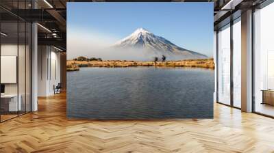 Couple hiking Pouakai circuit. Snow-capped Mt Taranaki in the background. New Zealand. Wall mural