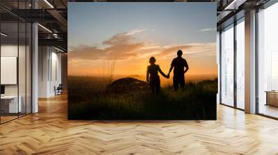 Silhouette couple standing on the hilltop looking at the sun rising over Auckland city. Photo taken at One Tree Hill. Wall mural