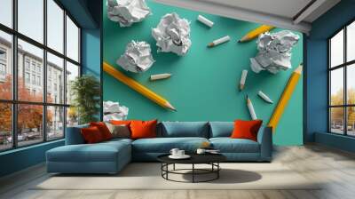 A green background with a pile of crumpled paper and a few pencils Wall mural