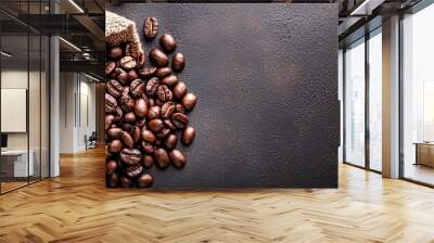  A sack of coffee beans beside a sack of coffee beans against a dark backdrop, with a few beans scattered nearby Wall mural