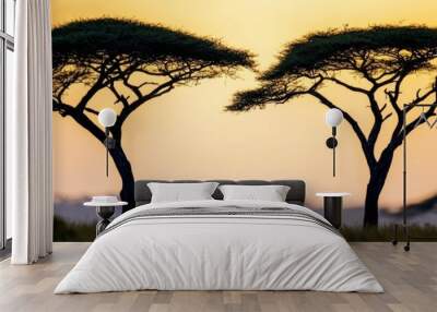  Two trees towering over a verdant field during sunset Wall mural