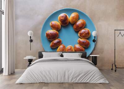 Meat pies on a blue plate with brown backgroud Wall mural