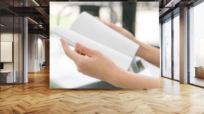 Hands open book on table . Wall mural