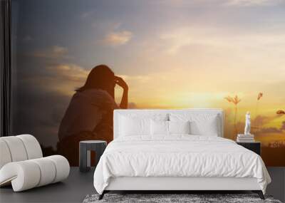 Silhouette of woman praying over beautiful sky background Wall mural