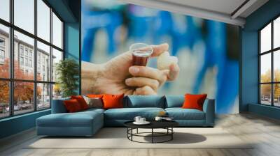 Hands hold a red wine cup in Holy communion Wall mural