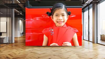 7 years old Happy Asian cute girl wearing Chinese red  dress holding Red envelope or Hong bao or Cheongsam. Chinese new year concept. Wall mural