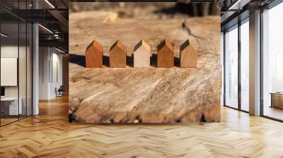 wooden house models on tree stump in the outdoors. concept image for wood as a renewable and sustainable building material for modular timber architecture.  Wall mural