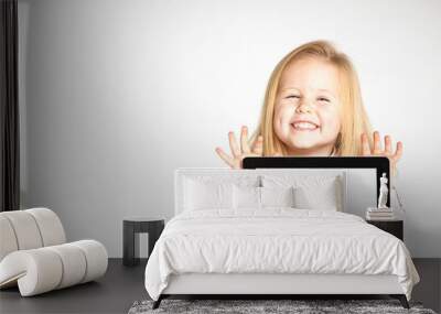 Cute little and smiling girl plays with a tablet Wall mural