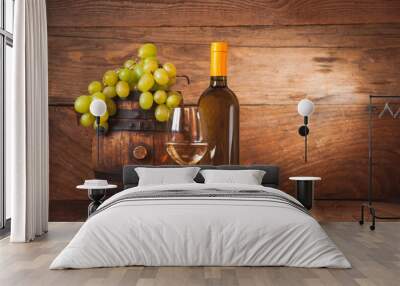 Glass of white wine with bottle and barrel on a rustic wooden ta Wall mural