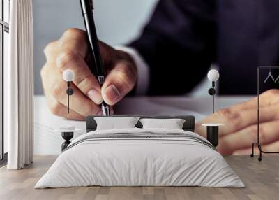 Businessman signing a document in office Wall mural