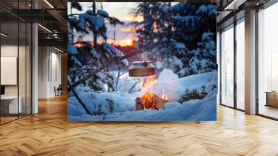 Fireplace and coffee pot in Finland. There is a sunset in the background. There is a lot of snow and frost. Wall mural