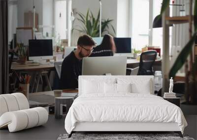 A tech startup team is formulating their strategy while occupying an office. Wall mural