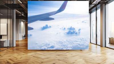 Clear blue sky with fluffy ornamental cumulus clouds, panoramic view from an airplane, wing close-up. Dreamlike cloudscape. Travel, tourism, vacations, weekend, freedom, peace, hope, heaven concepts Wall mural