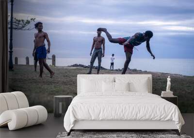 Young men exercising martial arts on the beach Wall mural