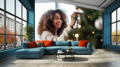  Beautiful young woman decorating a Christmas tree Wall mural