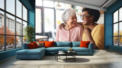  Happy smiling middle aged female friends sitting in a café laughing and giving support each other. They are celebrate a long friendship Wall mural