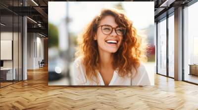  Portrait of happy young woman wearing glasses outdoors Wall mural