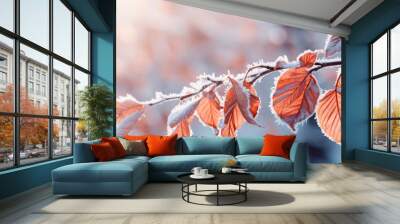 Beautiful branch with orange and yellow leaves in the forest covered with first snow. Autumn winter background Wall mural