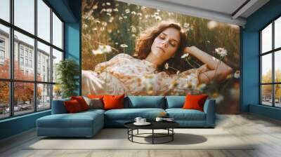 Beautiful young woman lying in the field with chamomile flowers  Wall mural