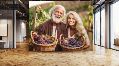 Happy smiling couple holding a wicker basket full of grapes in the vineyards in tuscany Wall mural