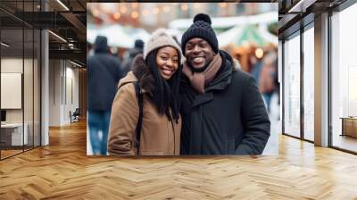 Happy young smiling black couple in winter clothes at street Christmas market in Stockholm Wall mural