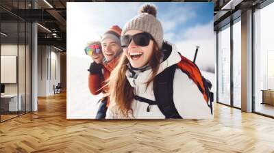 Happy young woman with sunglasses and winter clothing having fun with friends in ski resort Bukovel, winter holiday concept. Wall mural