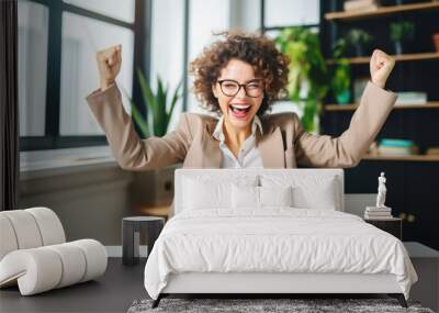 Portrait of a happy cheerful young business woman celebrating success with arms up in front of laptop. Freelancer finishing project at home. Wall mural