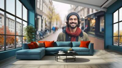 Portrait of a young smiling man standing on the city street in Amsterdam Wall mural