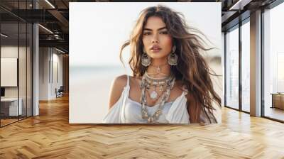 Portrait of beautiful woman standing on the beach, wearing stylish boho dress and jewlery Wall mural