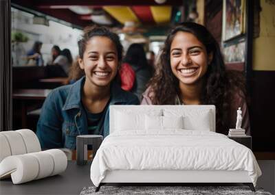 Portraits of two female friends sitting together in cafe and having fun in Bogota or Rio or Caracas Wall mural