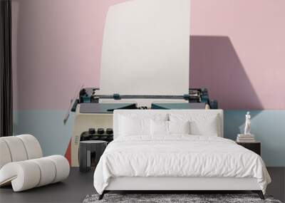 Pastel pink and blue background against retro vintage typing machine and paper. Creative retro concept. Retro futurism. Wall mural