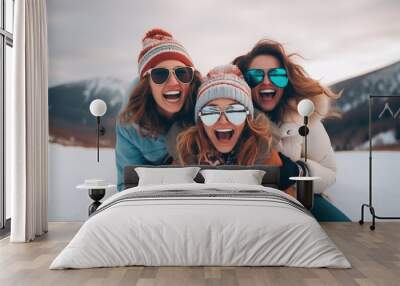 Three beautiful happy young women with sunglasses and winter clothing having fun in ski resort Bukovel, winter holiday concept. Wall mural