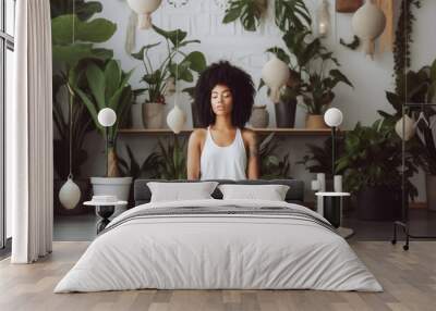 Young black woman sitting on the floor and meditating in a beautiful room in her home Wall mural